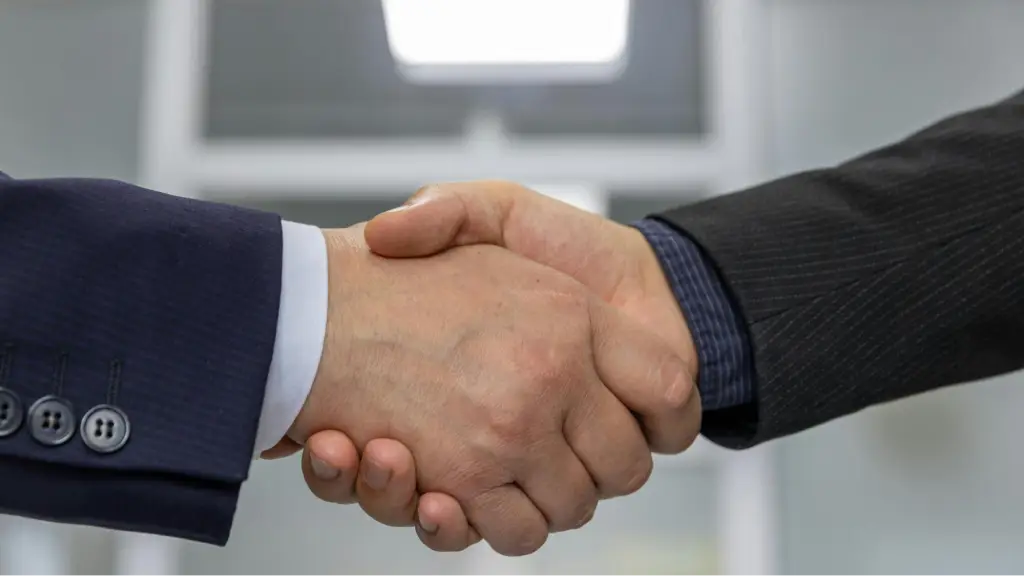 Two professionals shake hands, symbolizing trust, credibility, business partnerships, and building strong authority signals for long-term success.