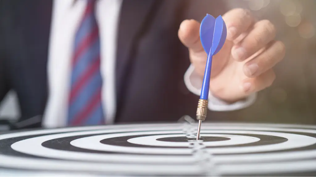 Capturing Targeted Traffic with Social SEO A person placing a dart on the center of a target board, symbolizing targeted traffic, precise audience targeting, goal achievement, and strategic social SEO efforts to improve marketing performance.