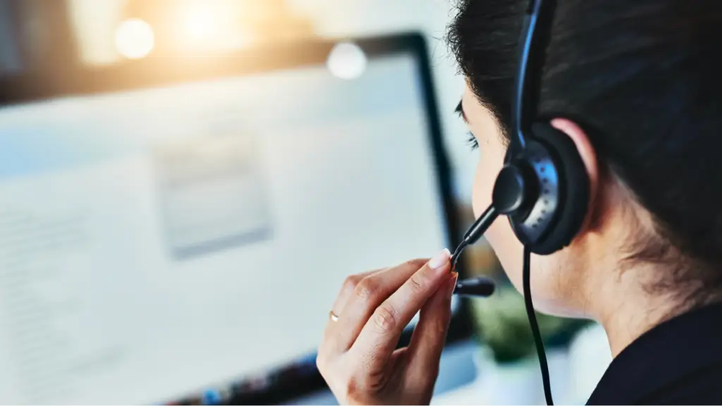A customer support professional wearing a headset while working at a computer, representing fast communication, workflow dashboard integration, real-time collaboration, and efficient business support operations.