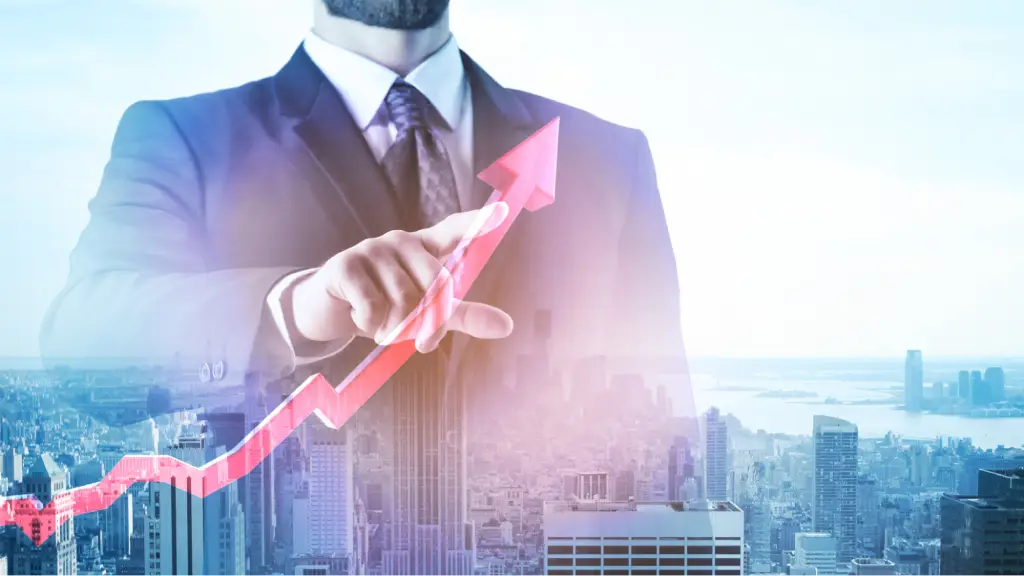 A double exposure image of a businessman in a suit pointing forward, overlaid with a rising red trend arrow and a panoramic skyline view of a major city.