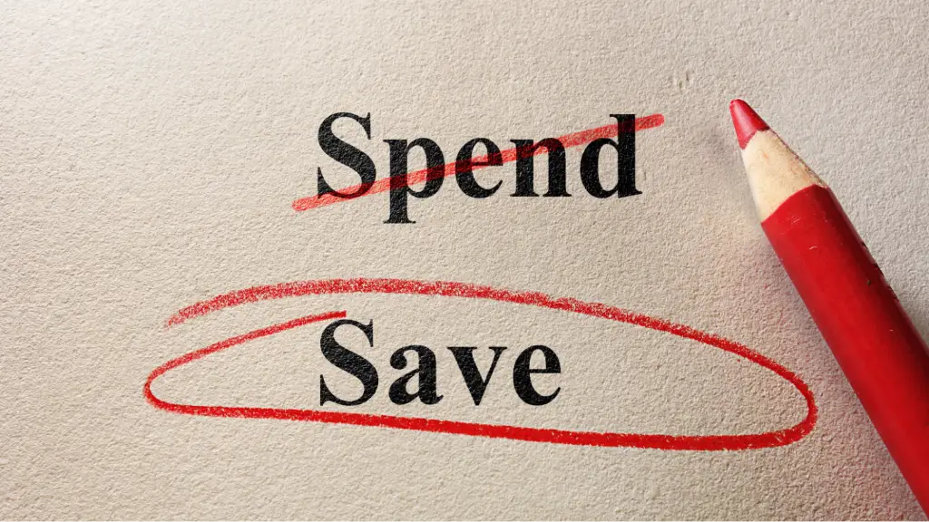 The words "Spend" and "Save" printed on a textured paper background, with "Spend" crossed out in red ink and "Save" circled in red next to a red pencil.