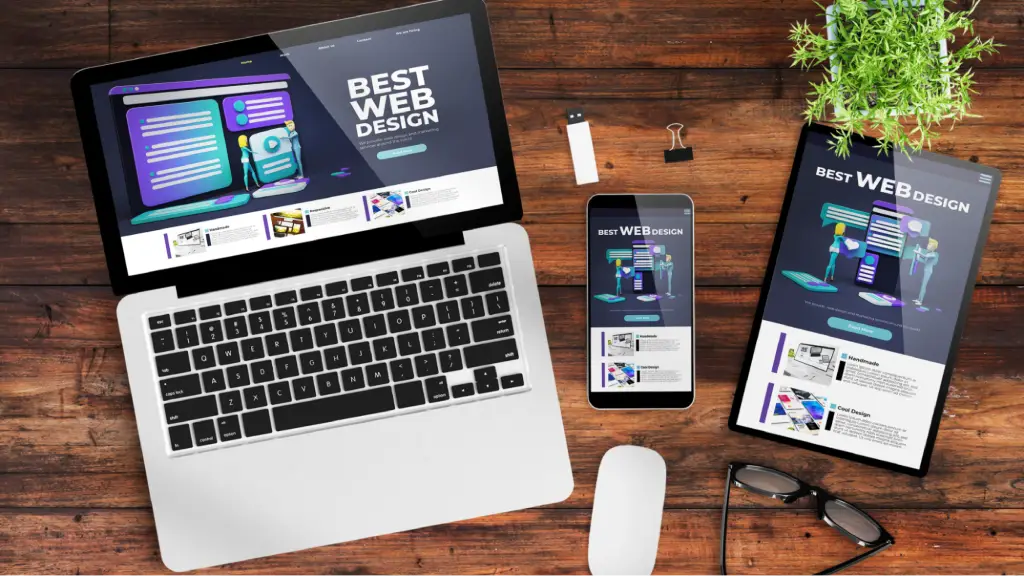 How Content Automatically Scales on Different Screens A laptop, smartphone, and tablet displaying the same website design on a wooden desk, illustrating responsive web design and how content automatically adapts and scales across different screen sizes and devices.