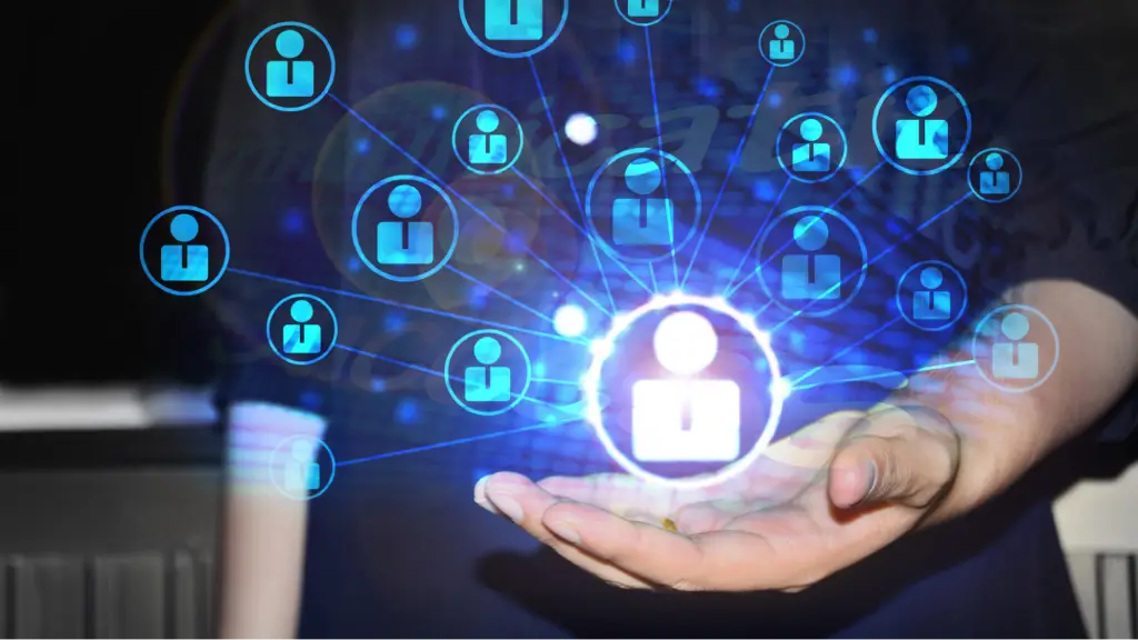 An open hand holding a glowing digital network diagram composed of interconnected blue user profile icons branching out from a central white profile icon.