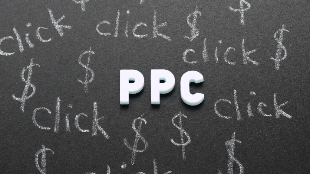 Navigating Predictive Modeling and Post-Cookie Attributions A chalkboard displaying the letters 'PPC' surrounded by the words 'click' and dollar symbols, representing pay-per-click advertising, predictive modeling, campaign analytics, and post-cookie digital marketing strategies.