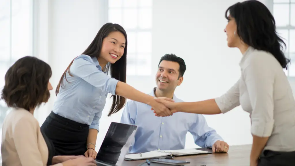 Securing Long-Term Client Loyalty (2) A group of business professionals shaking hands during a meeting, symbolizing trust, collaboration, long-term client loyalty, and strong professional relationships that support ongoing business success.