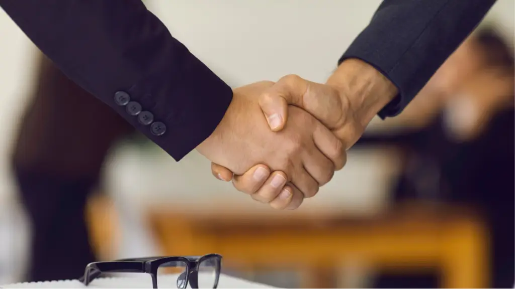 Securing Long-Term Client Loyalty A close-up of two business professionals shaking hands, symbolizing trust, long-term client loyalty, successful partnerships, and strong professional relationships that support sustained business growth.