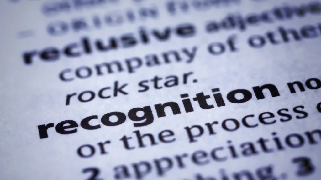 A close-up of the word “recognition” in a dictionary highlights the concept of entity recognition, brand identification, and semantic understanding in search.