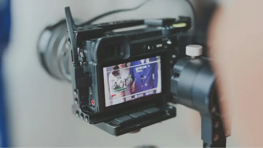 A professional video camera recording content, representing video production, filmmaking, content creation, and the technical process of producing expressive digital media assets.