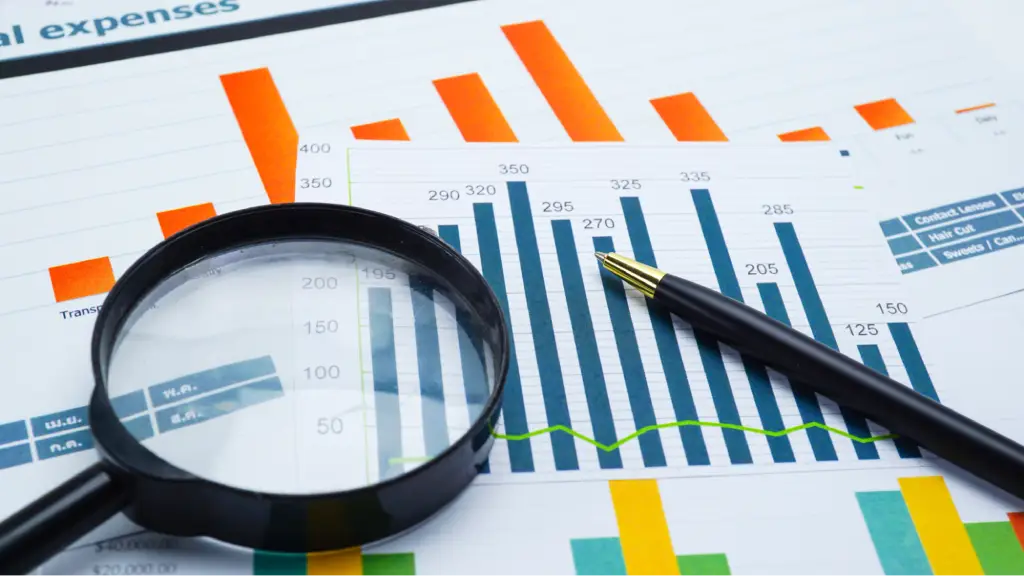 Technical Reporting Integration and Workflow Verification A magnifying glass and pen placed over financial charts and performance graphs, representing technical reporting, data analysis, workflow verification, business insights, and performance monitoring.