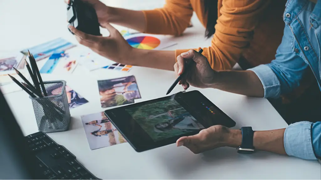 Key Benefits of Working With a Google Ads Management Agency USA A creative team collaborates using digital devices and marketing materials, representing expert Google Ads management, campaign optimization, and improved business performance.